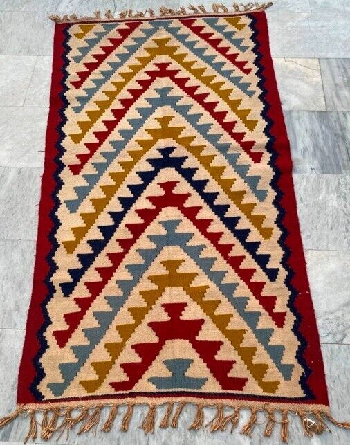 a multicolored rug with fringes on the floor