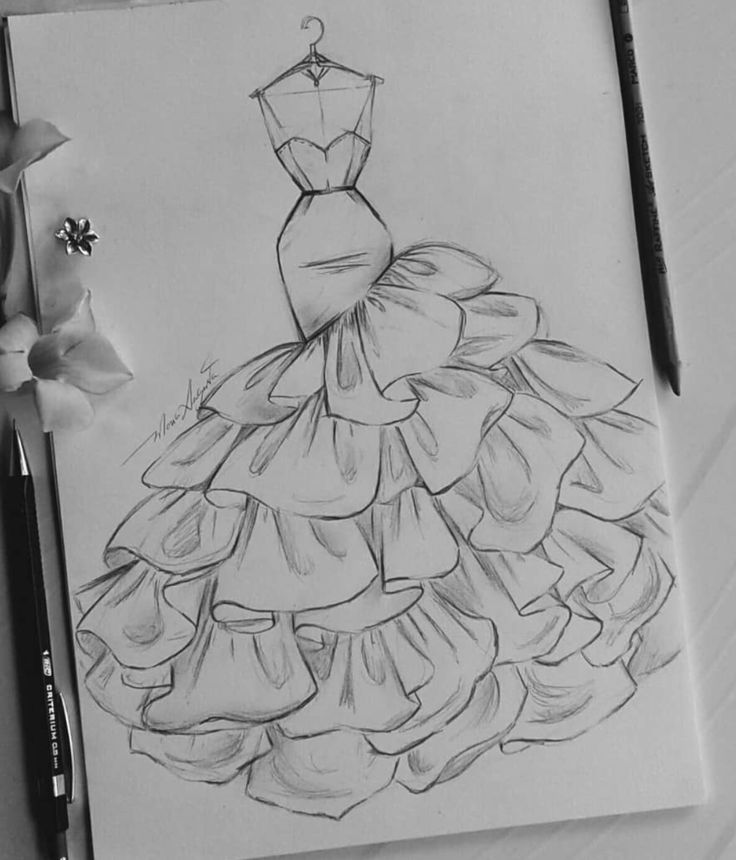 a drawing of a dress on paper next to flowers