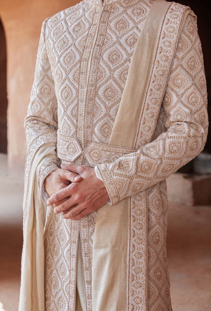 Editor's Note Step into refined elegance with our ivory taffeta silk sherwani, delicately adorned with gold dori, dabka, and bead embroidery. The ensemble is accompanied by an ivory monga tussar kurta and churidar, creating a harmonious blend of sophistication and tradition. This outfit is a perfect choice for showcasing understated luxury and timeless charm on your special occasion. Note: Stole and belt are for styling purposes only. Fabric: Tafetta silk and monga tussar Color: Ivory Components Blouse Yoke, Wedding Notes, Beaded Neckline, Mens Luxury Fashion, Ivory Silk, Kurta With Pants, Sherwani, Churidar, Embroidered Silk