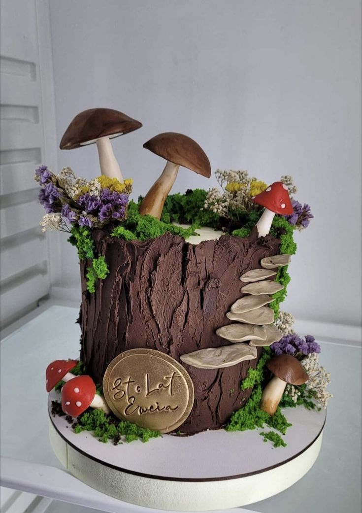 a cake decorated with mushrooms and plants on top of a table