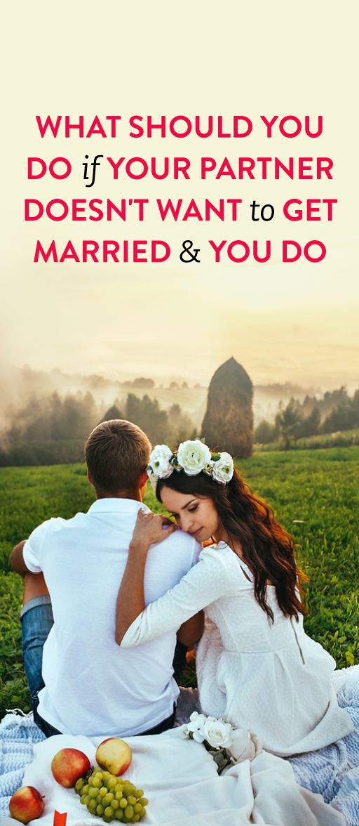 a man and woman sitting on top of a blanket next to each other in the grass