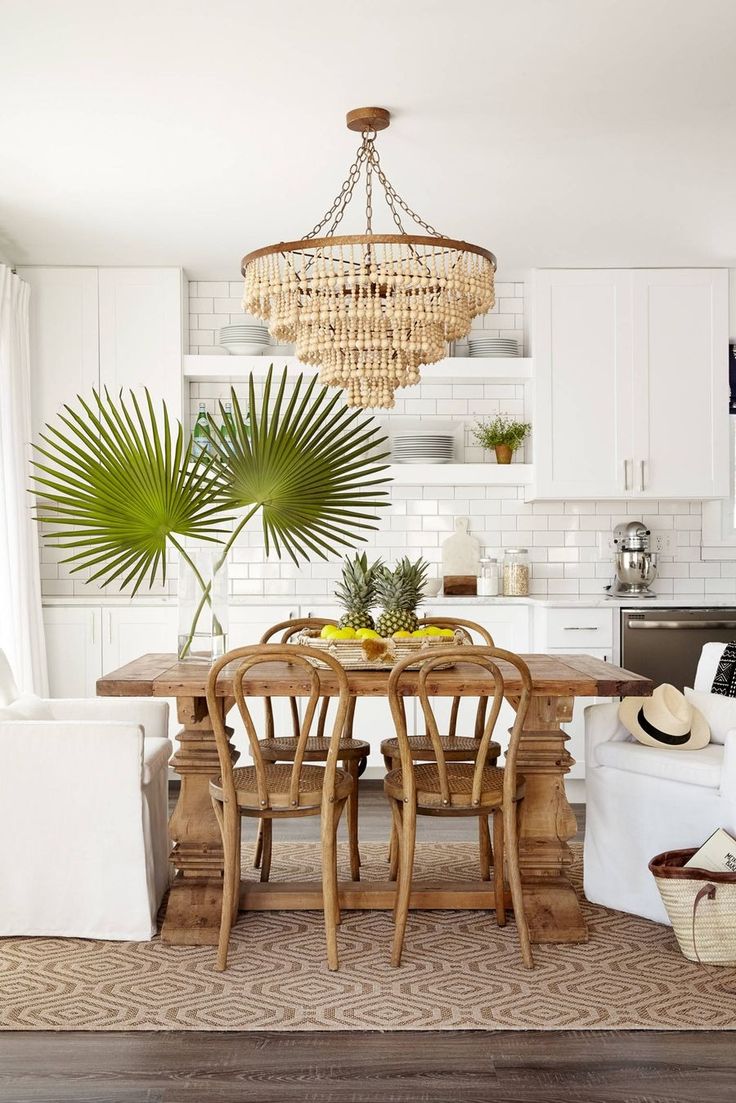 a dining room table with chairs and a chandelier hanging from it's ceiling