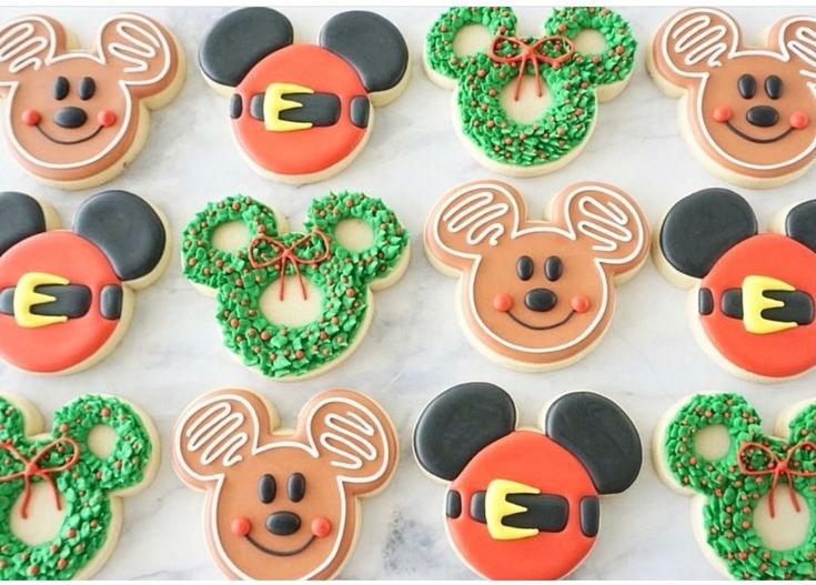 mickey and minnie mouse cookies decorated with icing on a marble counter top, ready to be eaten