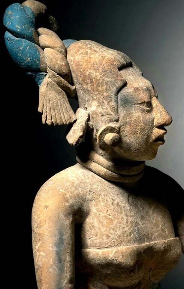 an old statue with a bird on it's head