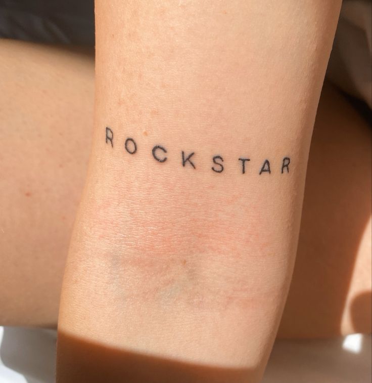 the word rockstar is written on someone's arm