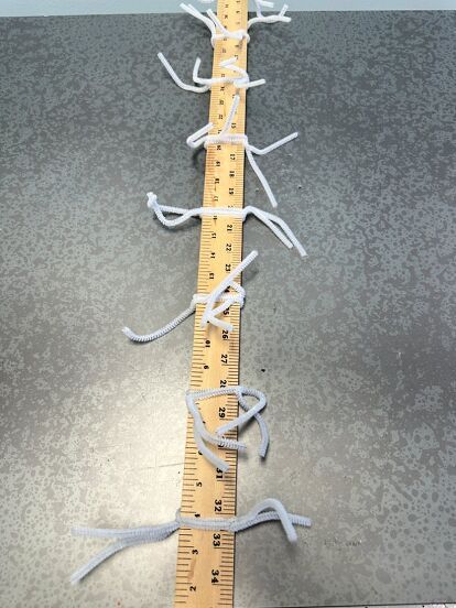 a ruler that has been taped to the floor with white tape and some scissors on it