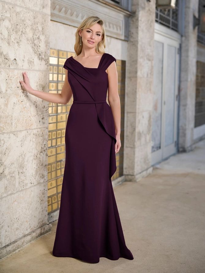 a woman in a long purple dress leaning against a wall with her hand on the side