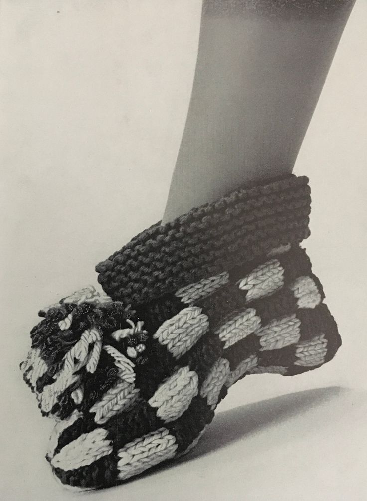 a woman's feet in knitted slippers with polka dots on the bottom