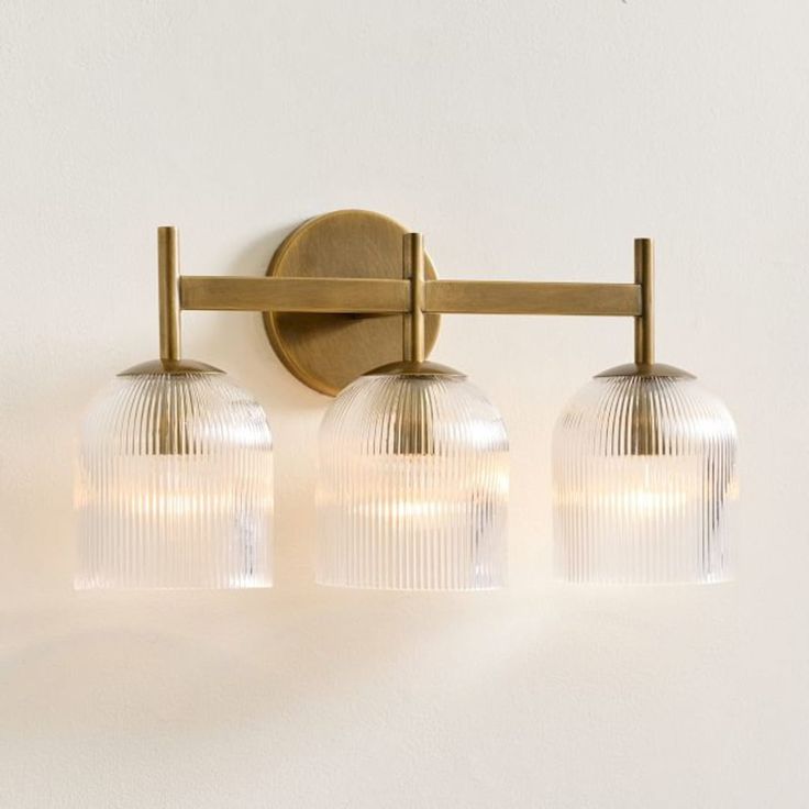 three light bathroom fixture with frosted glass globes on the back and brass finish