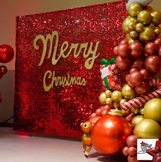 there is a christmas tree made out of balloons and balls in front of a merry sign