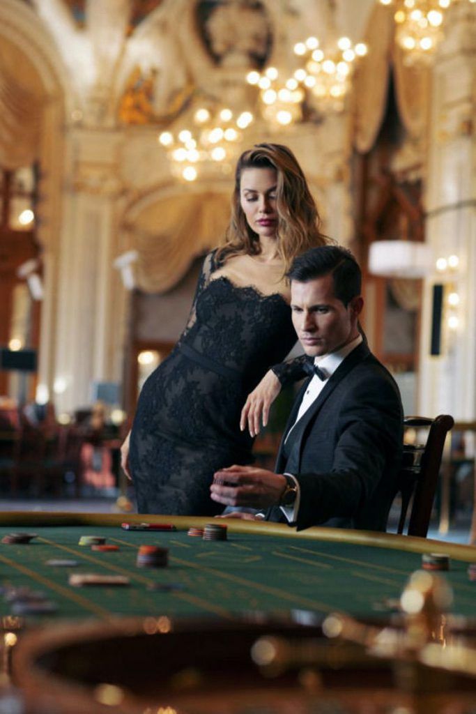 a woman in a black dress standing next to a man in a tuxedo