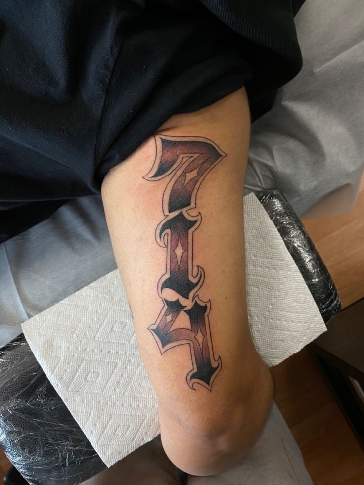 a person with a tattoo on their leg that has the letter f tattooed on it