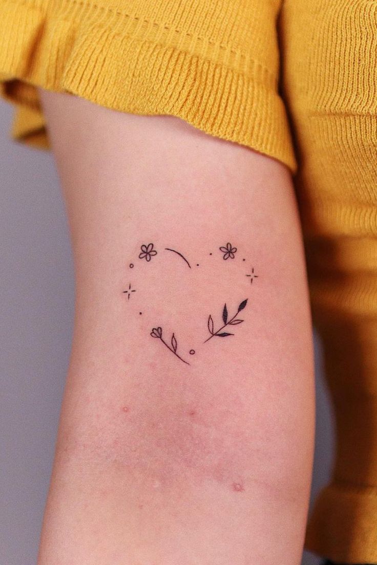 a woman's thigh with a small flower tattoo on it