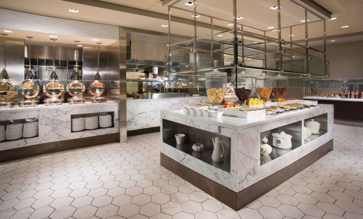 a kitchen filled with lots of counter top covered in glass and metal shelves next to each other