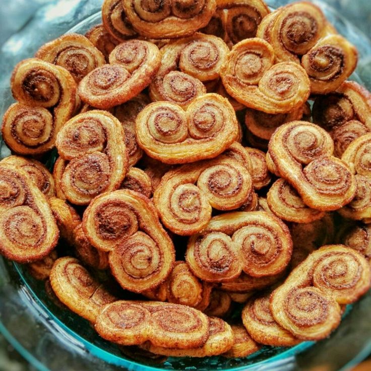 a bowl filled with cinnamon buns sitting on top of a table