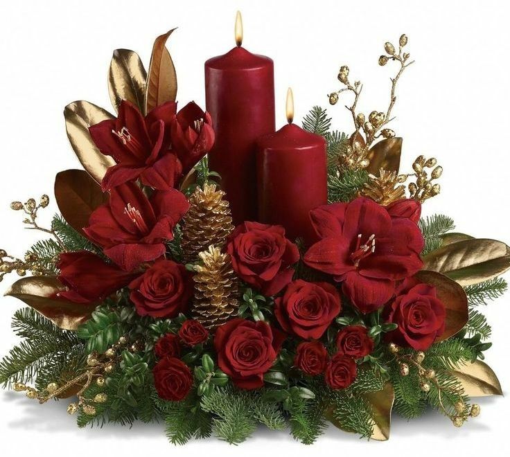 a christmas arrangement with red candles and greenery on a black background in the center