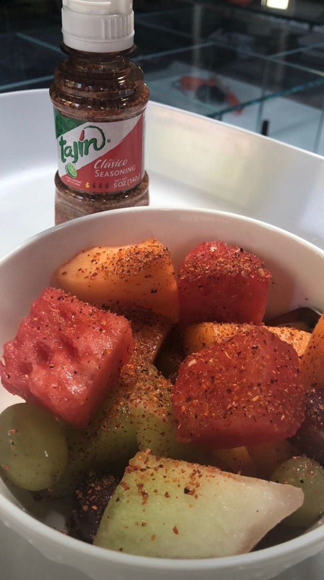 a white bowl filled with food next to a bottle of ketchup