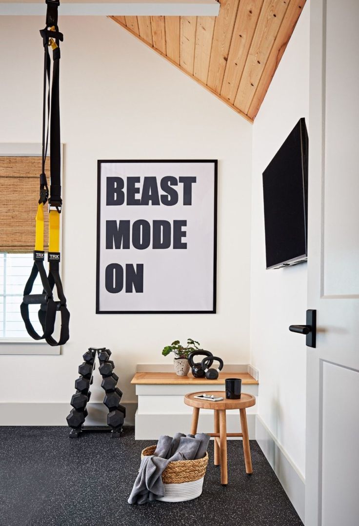 a black and white poster hanging on the wall next to a wooden table in a room