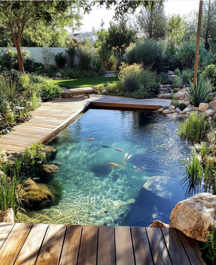 an outdoor swimming pool with wooden decking and clear blue water surrounded by greenery