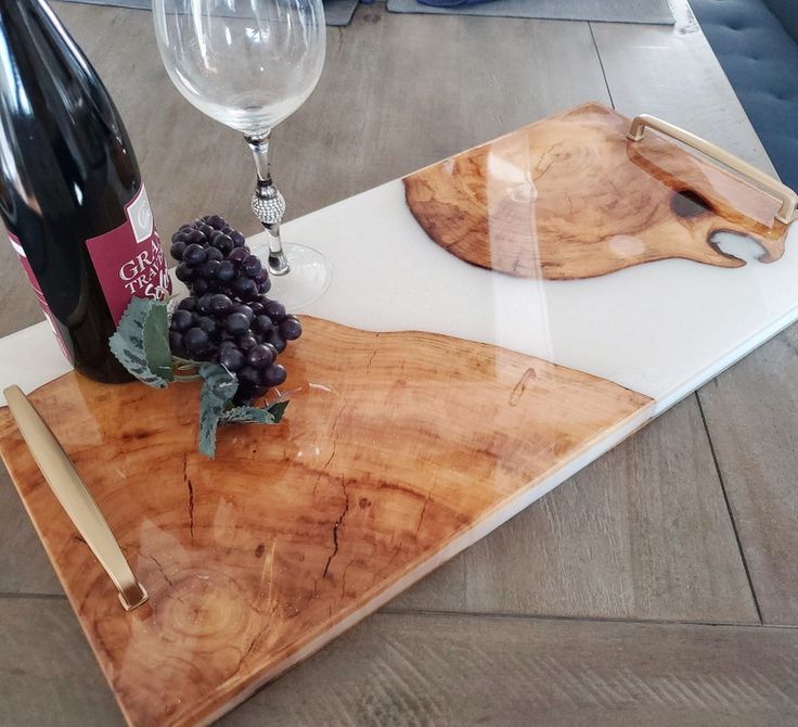 a wine bottle and some grapes on a wooden tray