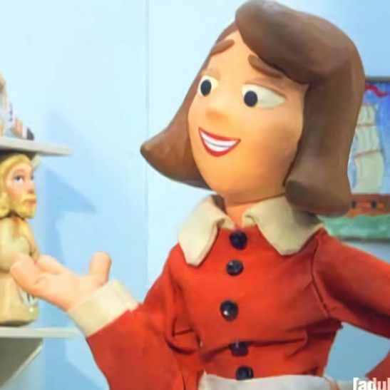 a close up of a person holding a doll in front of a shelf with dolls on it