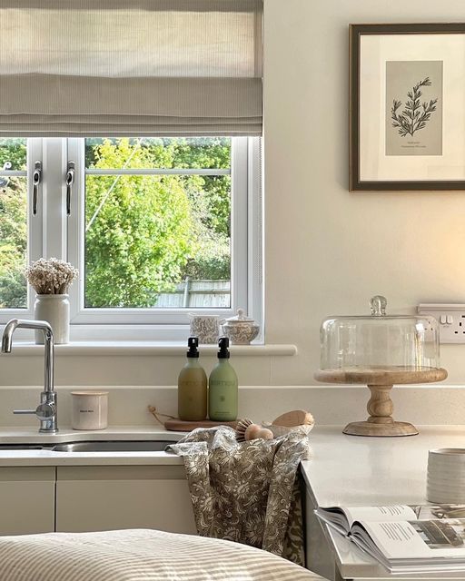 a kitchen sink sitting under a window next to a counter