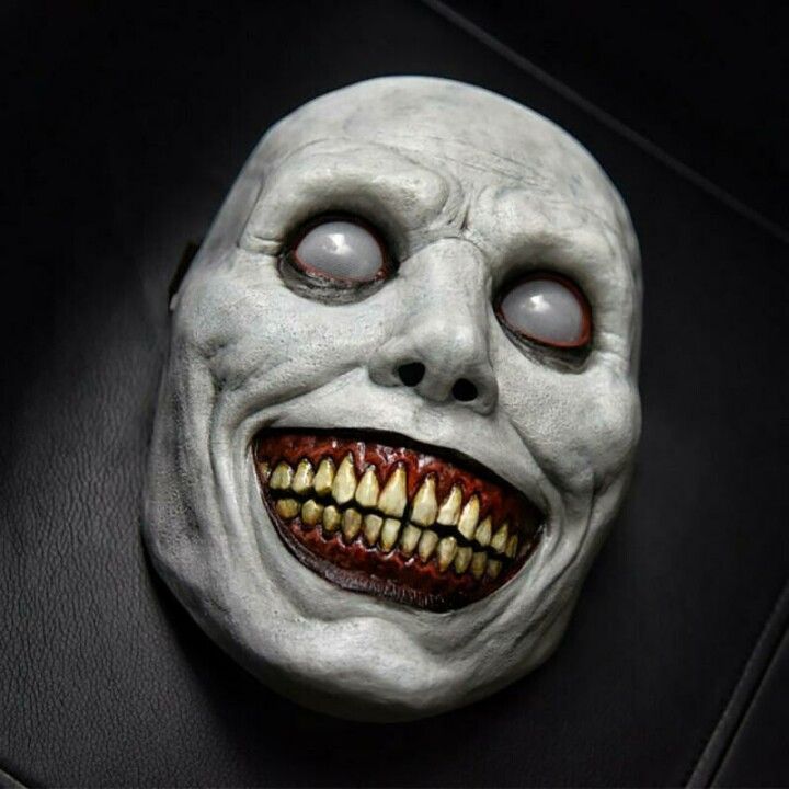 a creepy mask with red eyes and teeth