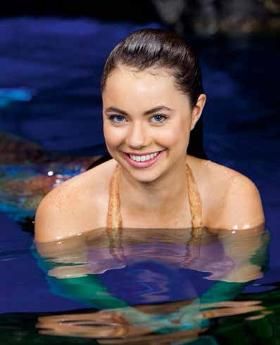 a young woman is smiling in the water