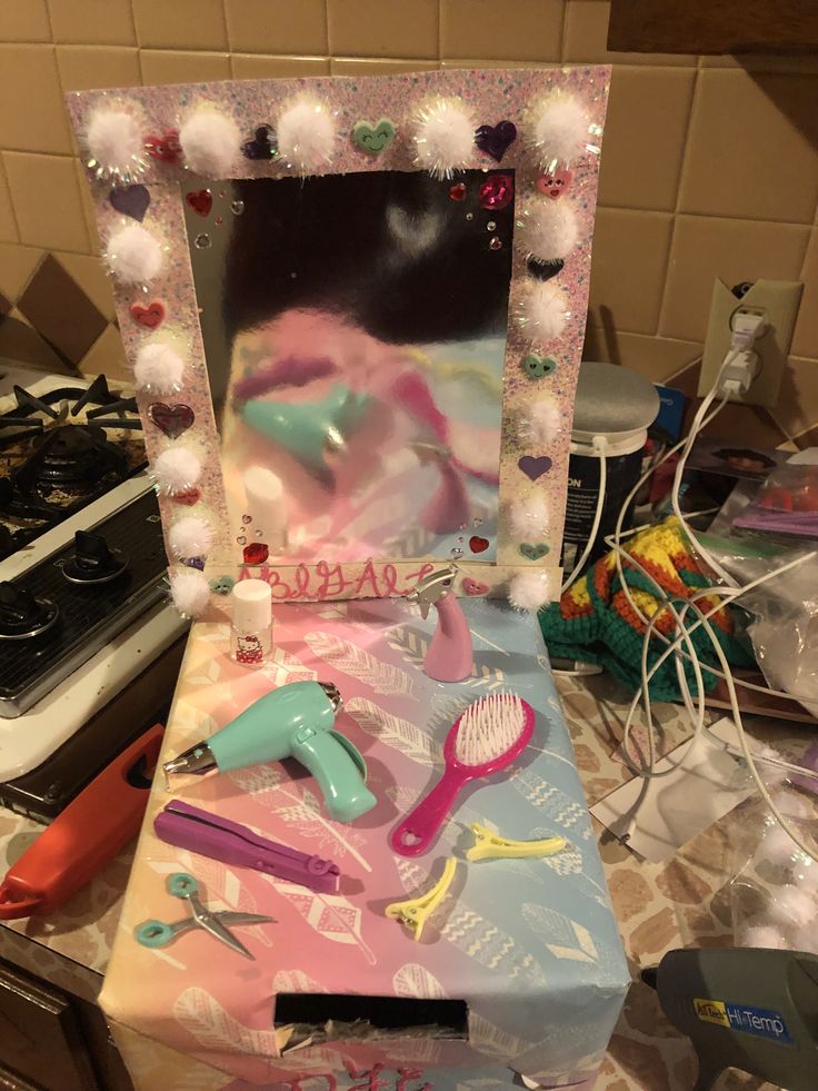 a vanity mirror sitting on top of a counter next to a hair dryer and comb