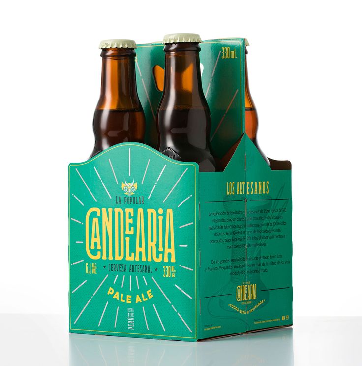 three beer bottles in a green box on a white surface