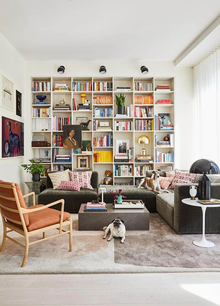 a living room filled with lots of furniture and bookshelves