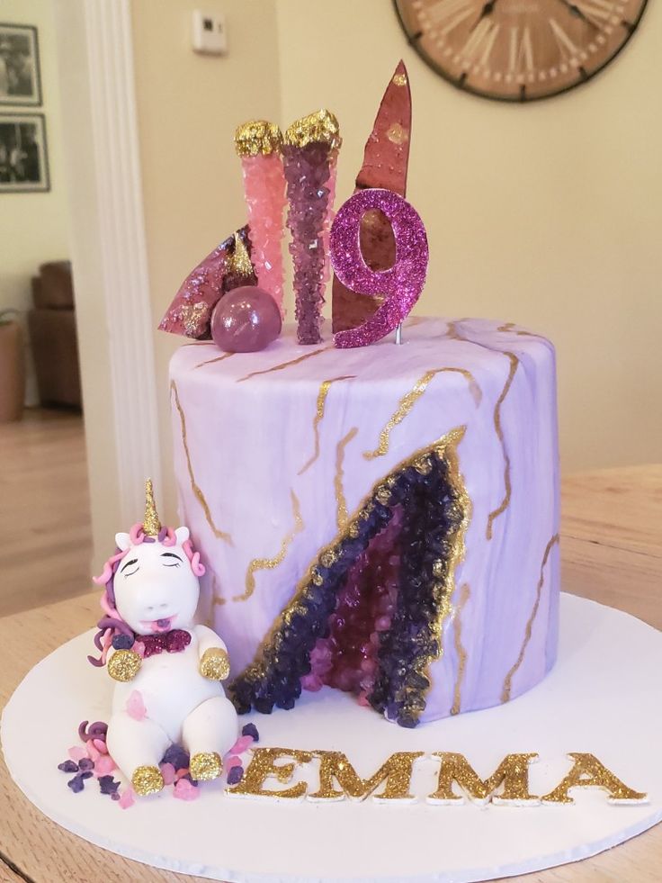 a birthday cake decorated with unicorns and letters