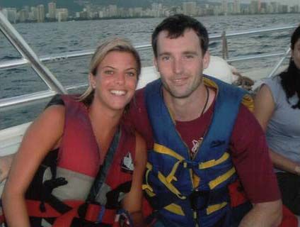 a man and woman on a boat in the water with life vests around their necks