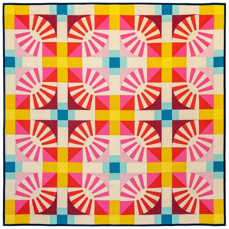 a colorful quilt is displayed on a white surface