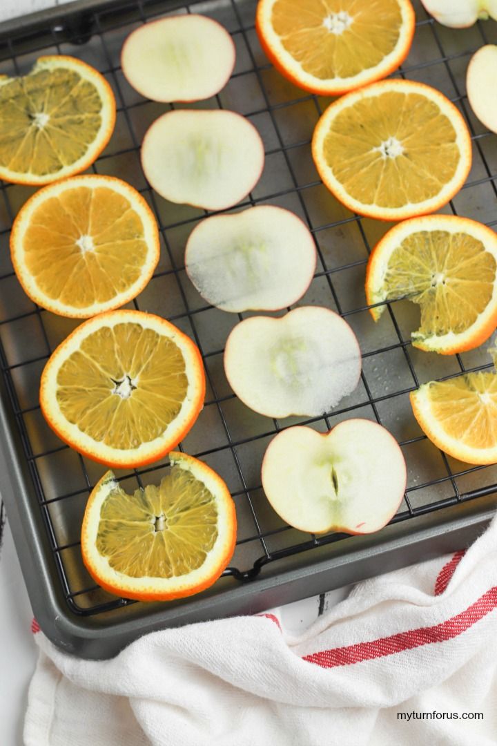 sliced oranges and apples on a baking tray ready to be cooked in the oven