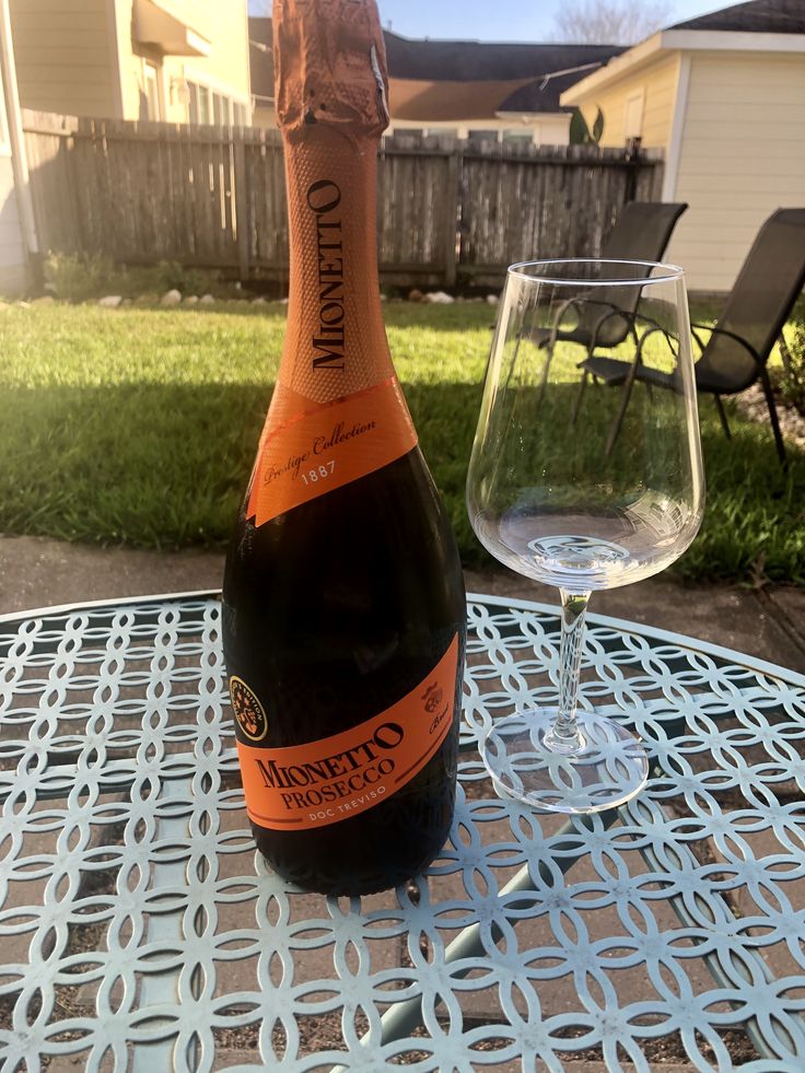 a bottle of wine sitting on top of a table next to a glass filled with water