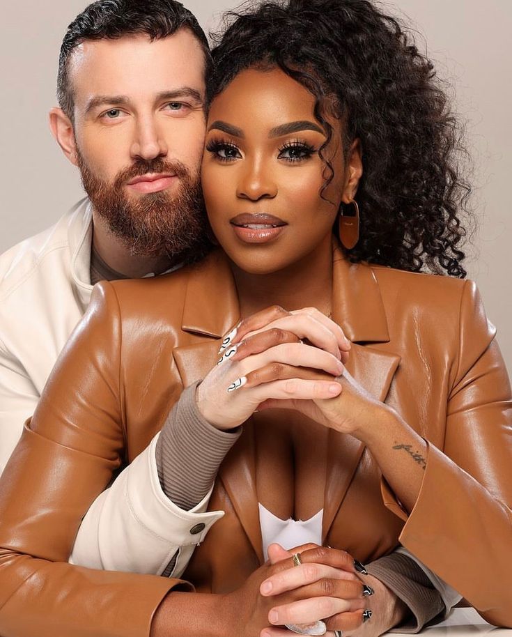 a man and woman are posing for a photo with their hands on each other's chest