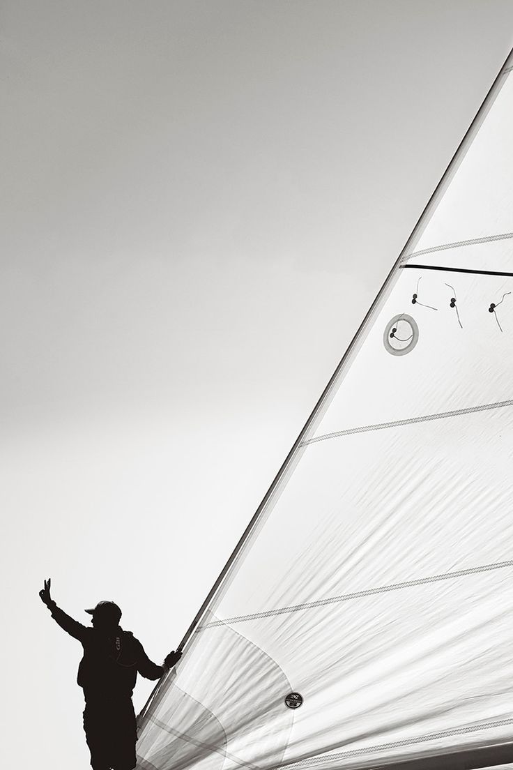 a man standing on the side of a sail boat