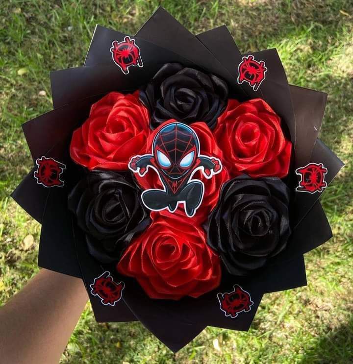 someone holding a bouquet of red and black roses in their hand with spiderman stickers on it