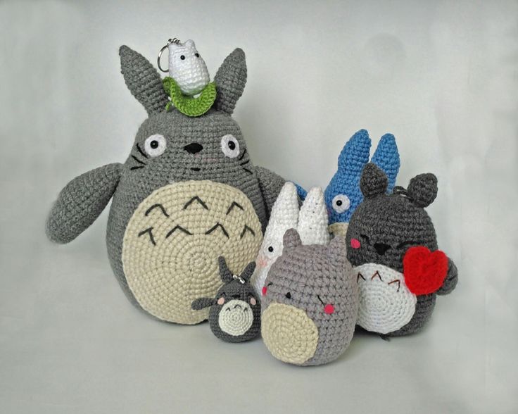 crocheted totoro and other stuffed animals are arranged on a white background