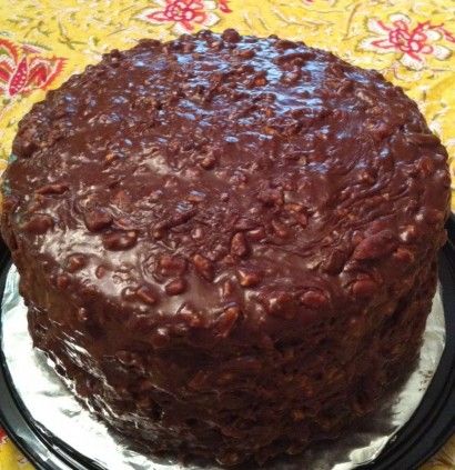 a chocolate cake sitting on top of a black plate next to a yellow table cloth