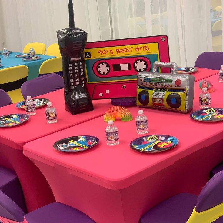 there is a pink table with purple chairs and a boombox on top of it