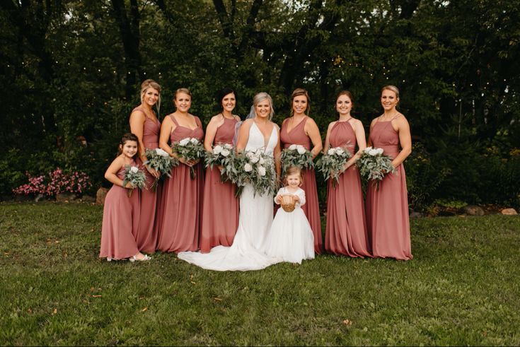 a group of women standing next to each other on top of a lush green field