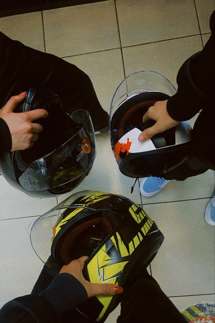 two people wearing helmets sitting on the floor