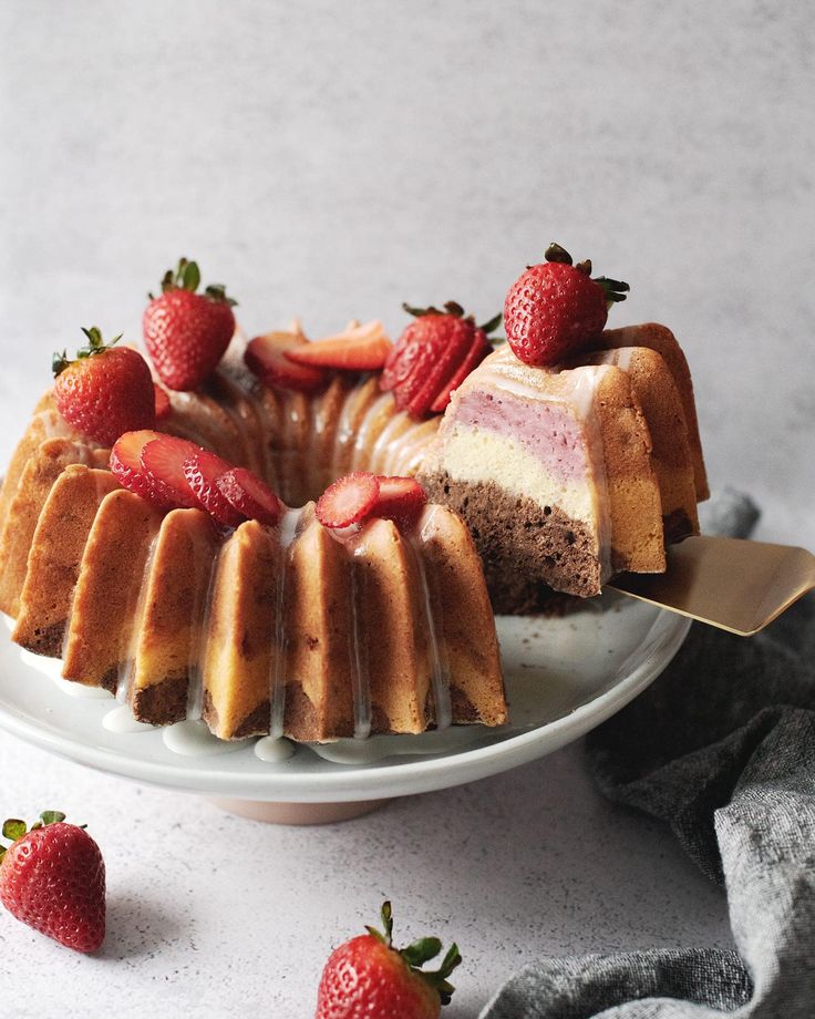 a cake on a plate with strawberries around it and one slice cut out from the cake