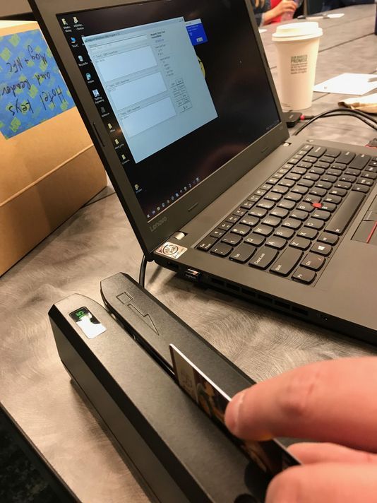 a laptop computer sitting on top of a table next to a hand holding a mouse