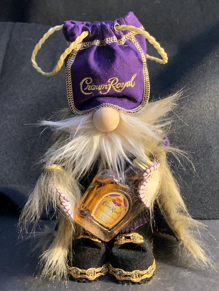 a stuffed animal with a purple bag on it's head and some hair around its neck