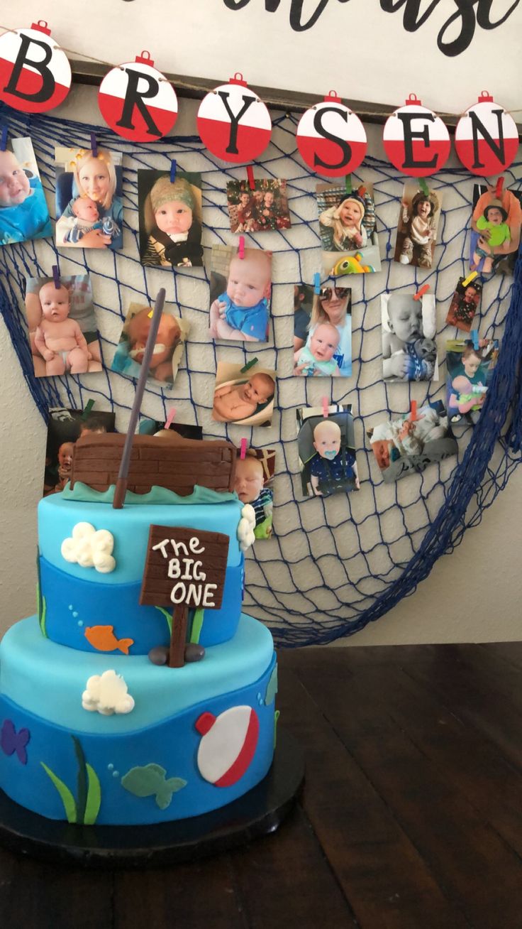 there is a blue cake with pictures on the front and back of it, along with a fishing net