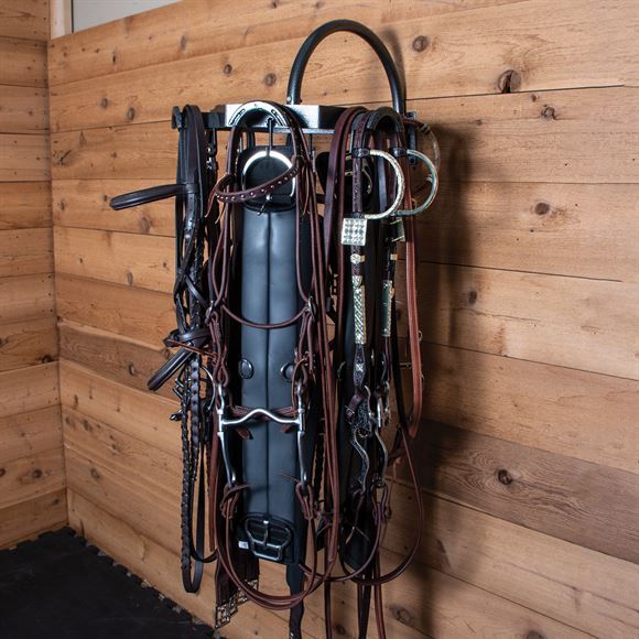 a wall mounted horse bridle with many different types of tacks on it