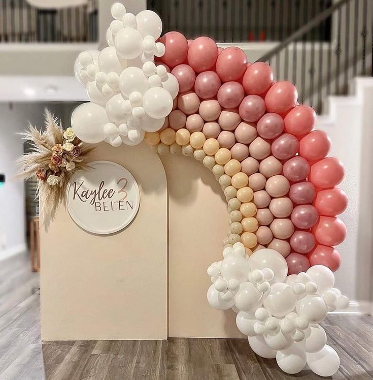 the balloon arch is decorated with pink, white and gold balloons